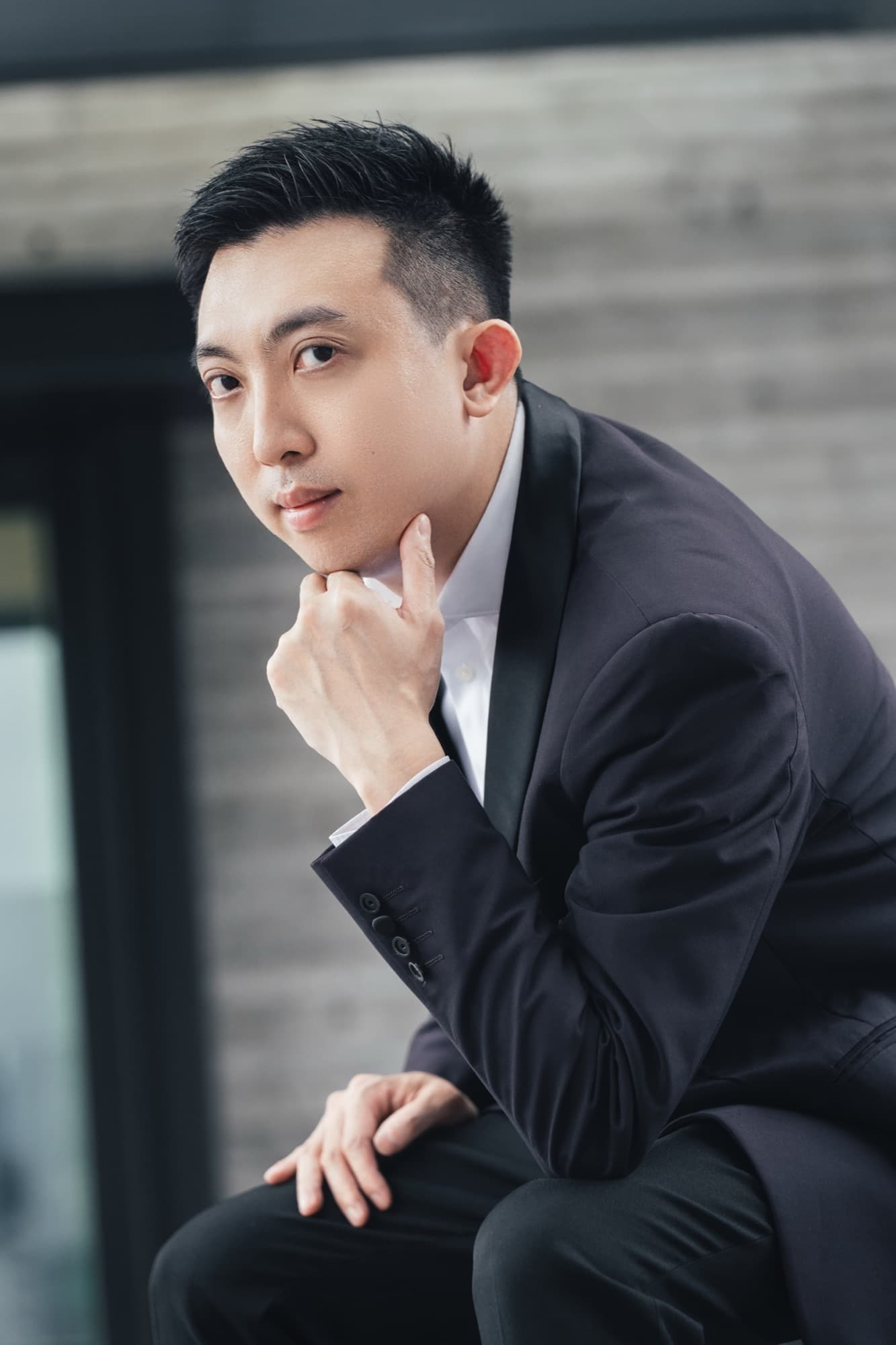 蕭始迪師傅身穿黑色西裝的近照